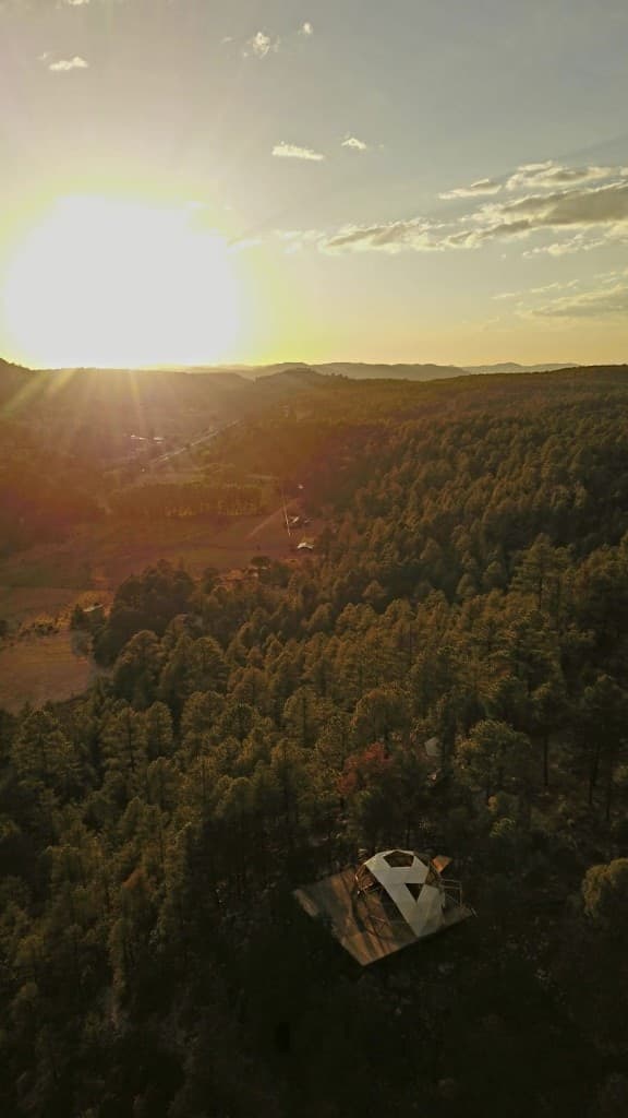 Domo geodésico al atardecer en el bosque de pinos cerca de Creel